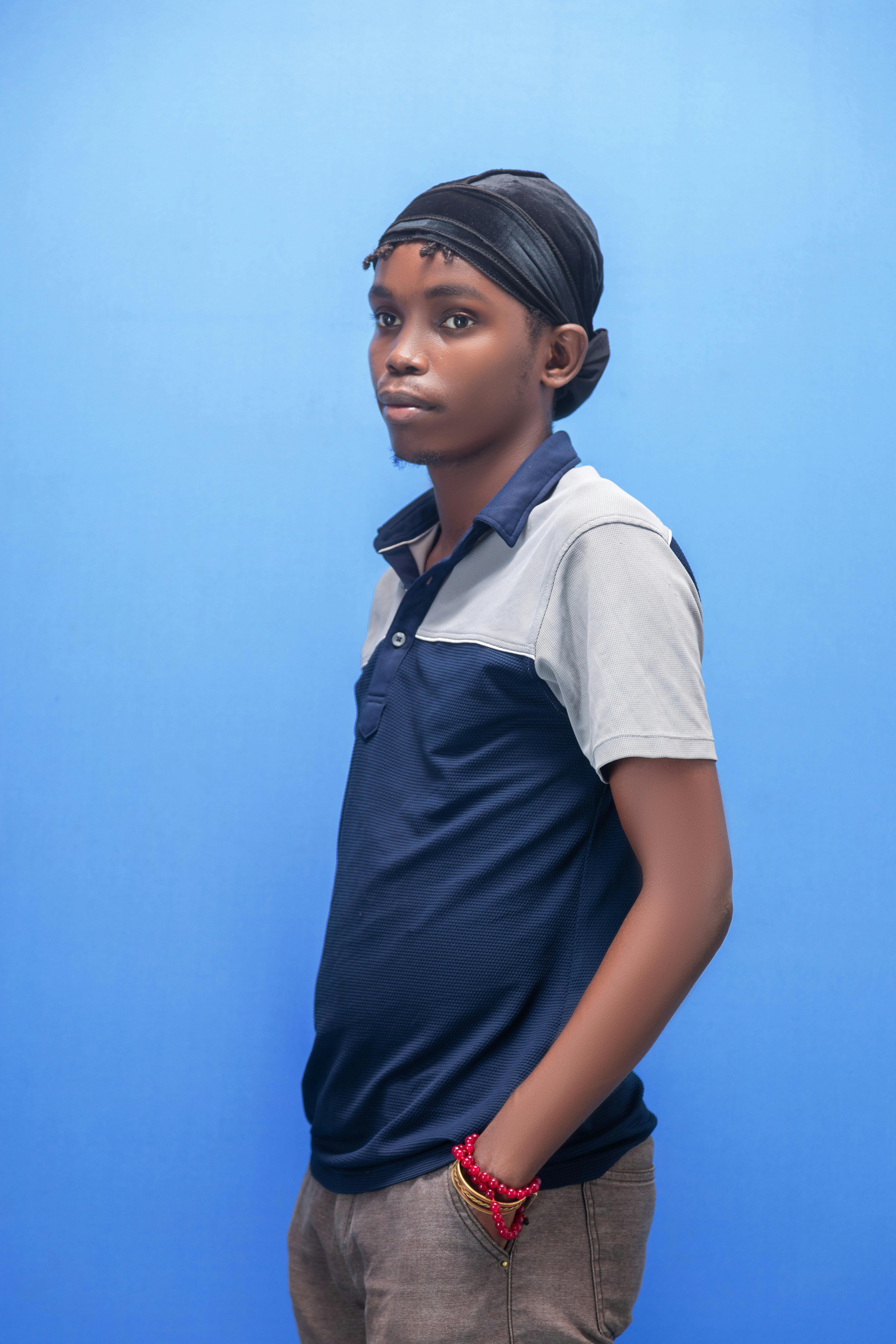 grátis Foto de perfil de um jovem contra um fundo azul simples. Foto profissional