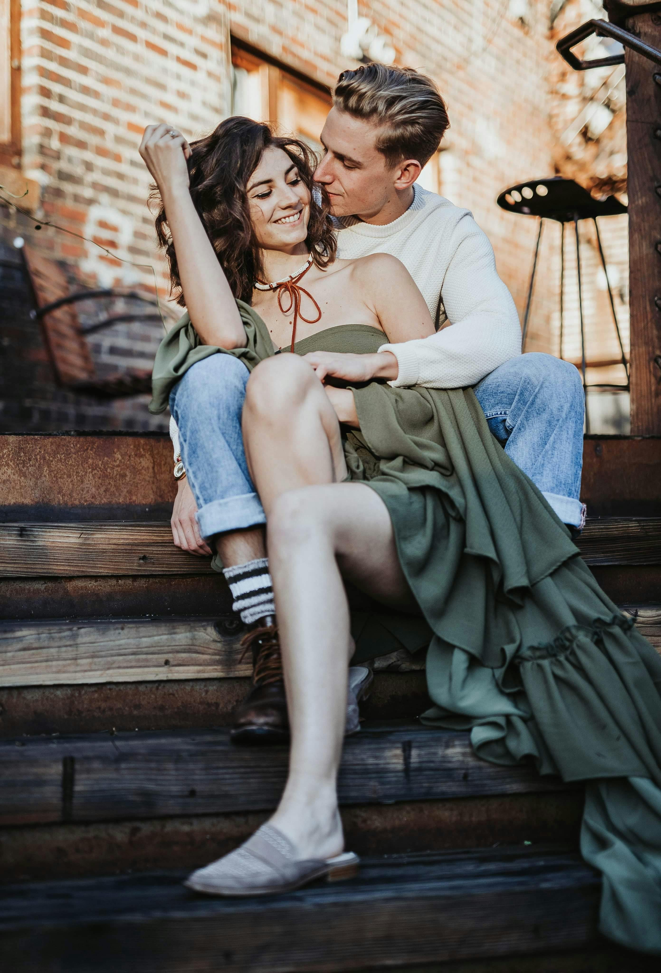 Happy Young Attractive Couple Sitting Closely In Forest