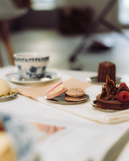 Free Close-up of various elegant desserts and a cup of coffee on a white table with a modern interior. Stock Photo