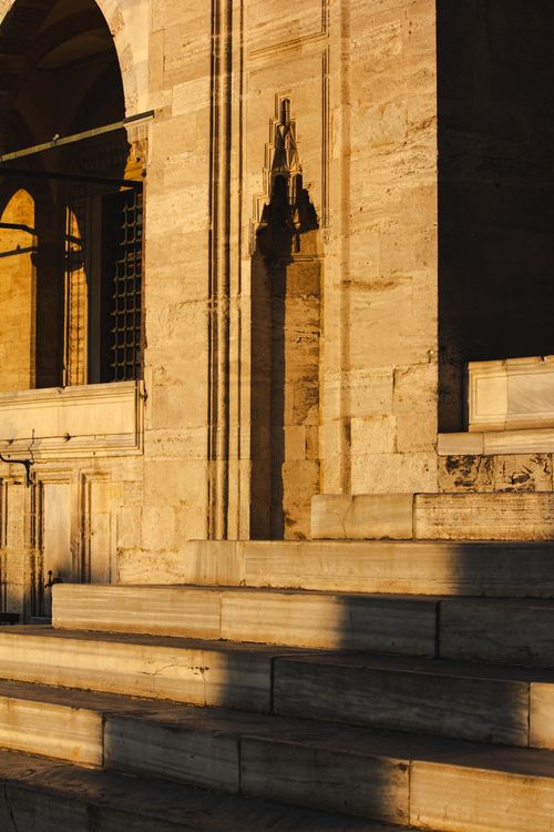 Free Golden hour light casts dramatic shadows on historic stone architecture, emphasizing intricate details. Stock Photo