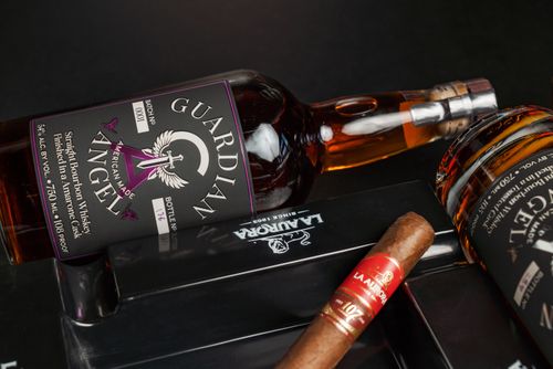 Free Premium Guardian Angel bourbon and cigar arrangement, reflecting upscale New Orleans nightlife ambiance. Stock Photo