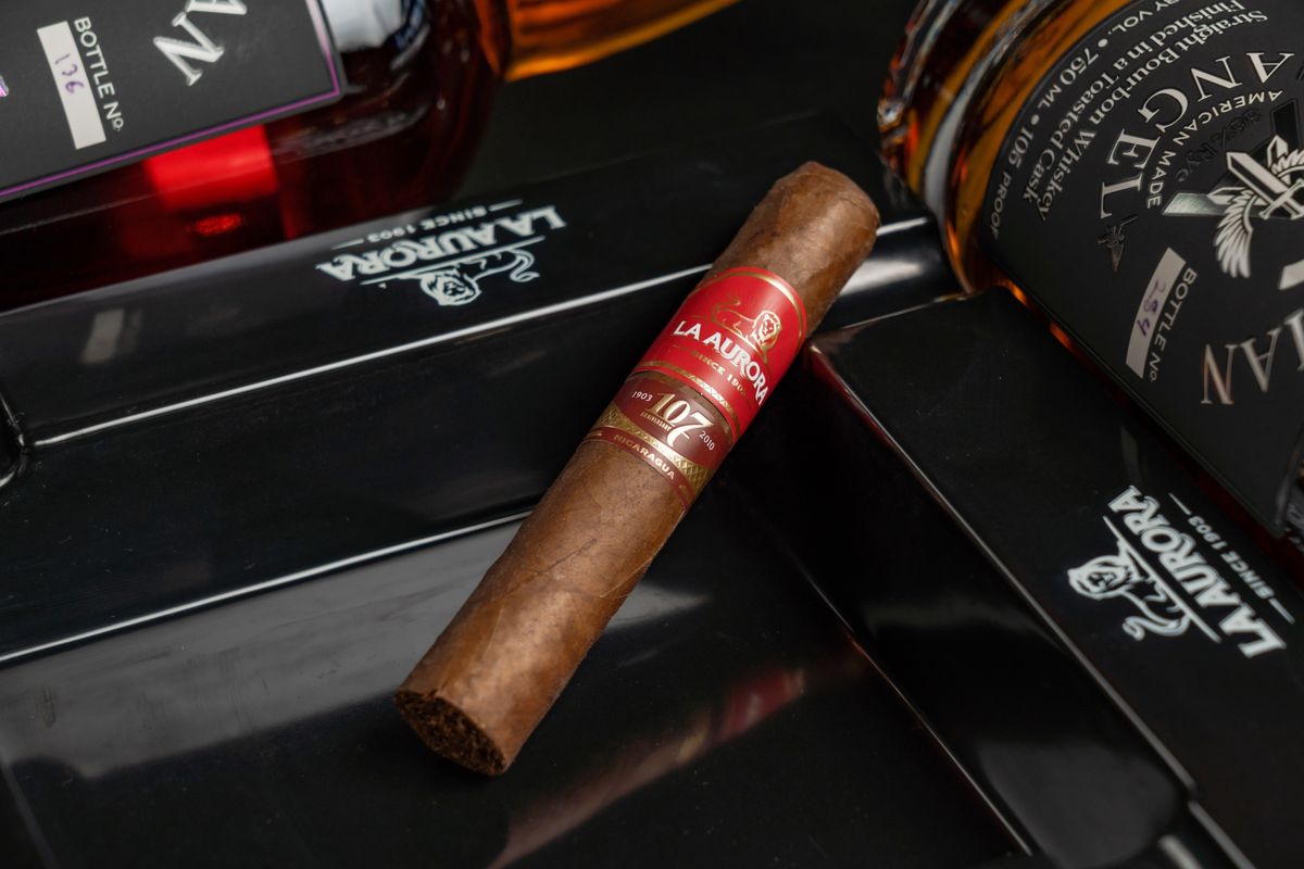 Composicao premium com garrafas de whisky e charuto sobre superficie preta