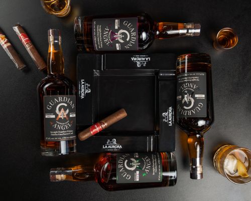 Free A captivating flat lay of Guardian Angel bourbon bottles and cigars in New Orleans bar ambiance. Stock Photo
