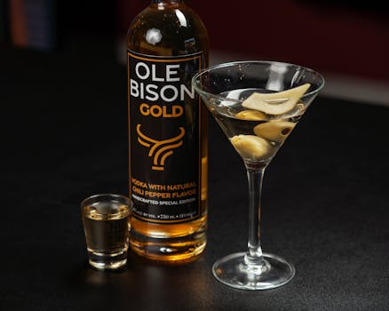 Ole Bison Gold vodka with chili pepper flavor, featuring a martini glass with olives, photographed in New Orleans.