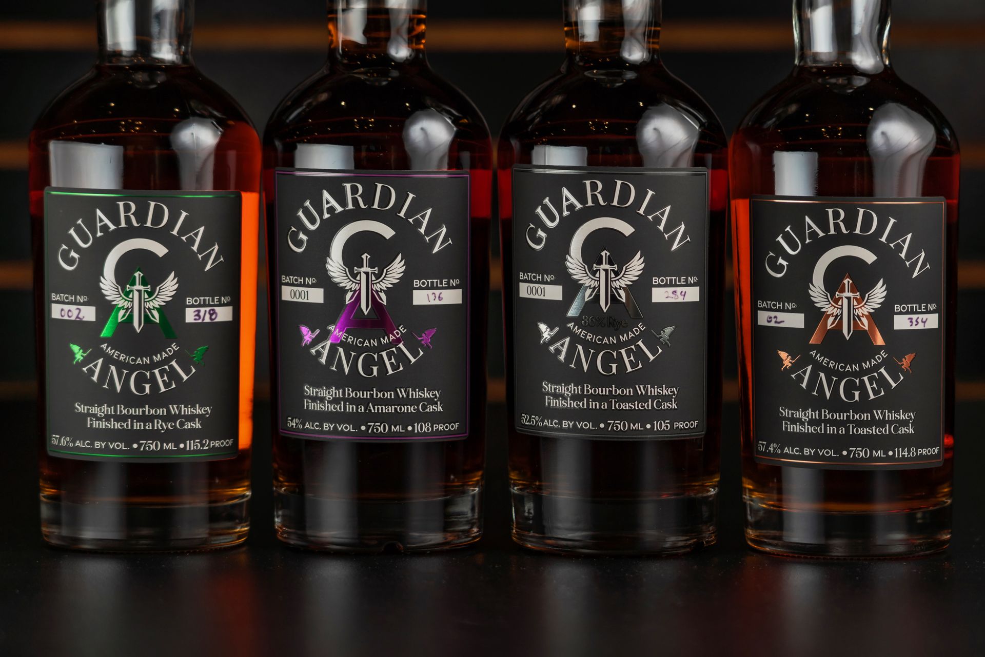 A selection of Guardian Angel straight bourbon whiskey bottles finished in various casks on display.