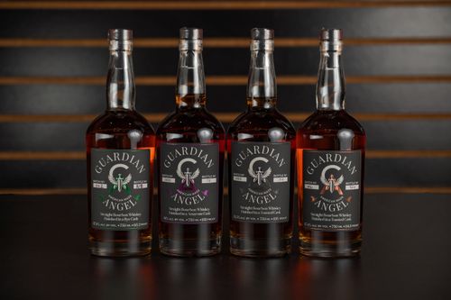 Free Four Guardian Angel bourbon bottles displayed indoors at a New Orleans bar. Stock Photo