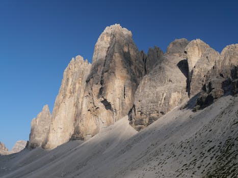 Explore the towering Tre Cime di Lavaredo in Italy's Dolomites, bathed in golden evening light.