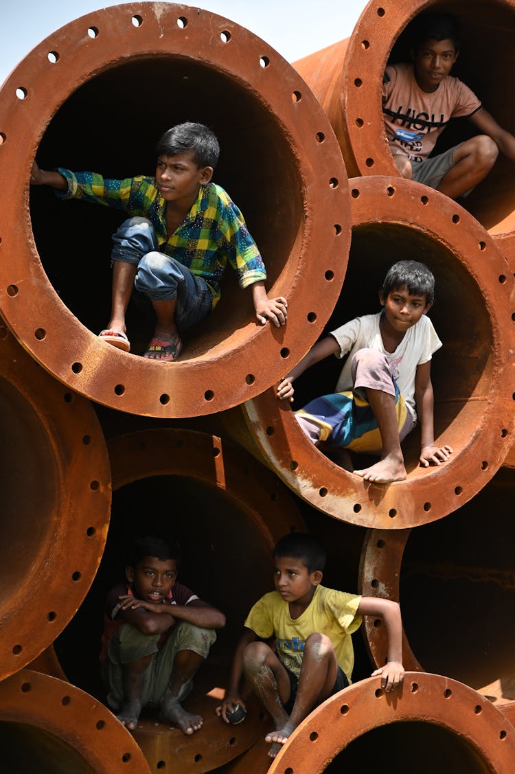 Boys Sitting In Piled Culvert