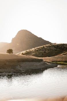 Peaceful sunrise over a river with a mountain backdrop, evoking tranquility.