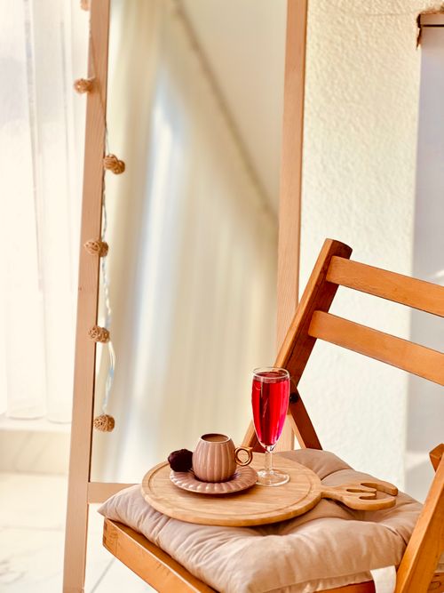 Free Warm interior with wooden chair, mirror, and a cozy drink setup. Stock Photo