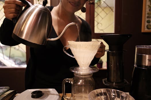 Barista preparing fresh pour-over coffee in a cozy Ecuadorian cafe setting.