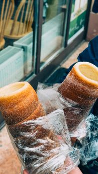 Tasty chimney cakes being enjoyed on a street in Budapest, Hungary, showcasing local flavor.