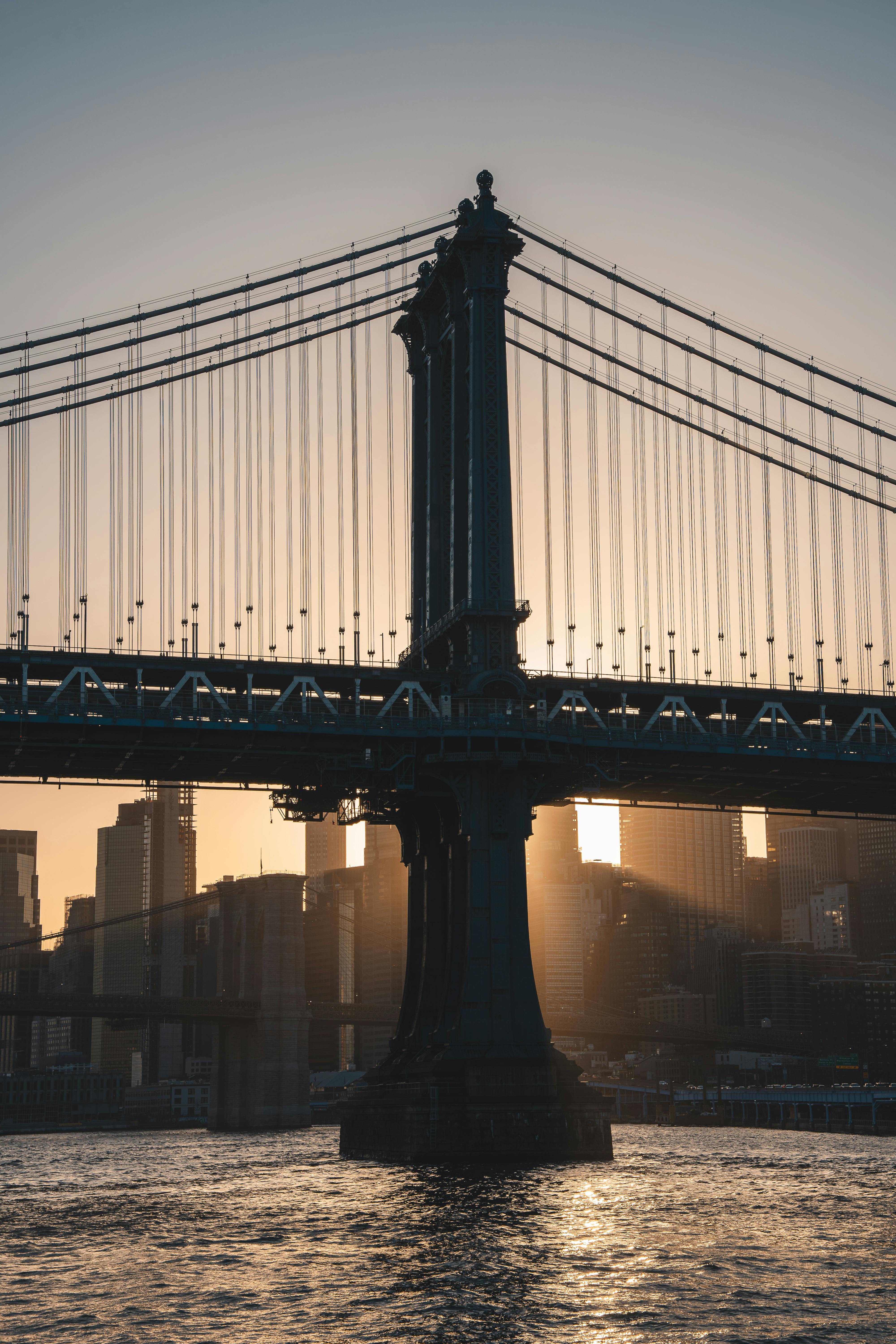 在纽约市，夕阳映照下，曼哈顿大桥呈现出戏剧性景观