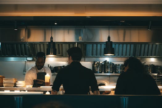 Chefs working in a bustling New York kitchen, evening scene.