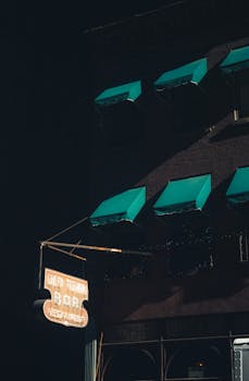 Moody night scene of Old Town Bar with neon sign and awnings in NYC.
