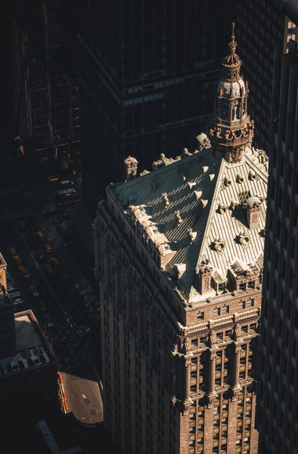 Aerial shot of a classic skyscraper in a cityscape, capturing architectural details and shadows.