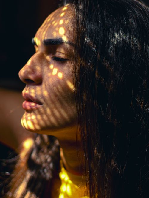 Free A serene portrait of a young adult with dramatic light patterns on face, evoking calm and introspection. Stock Photo