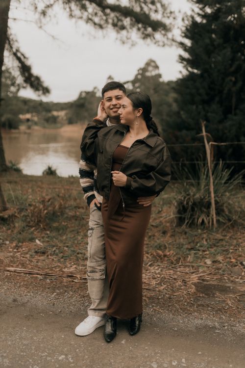 Free A young couple embraces by a lakeside in an autumn setting, exuding warmth and affection. Stock Photo