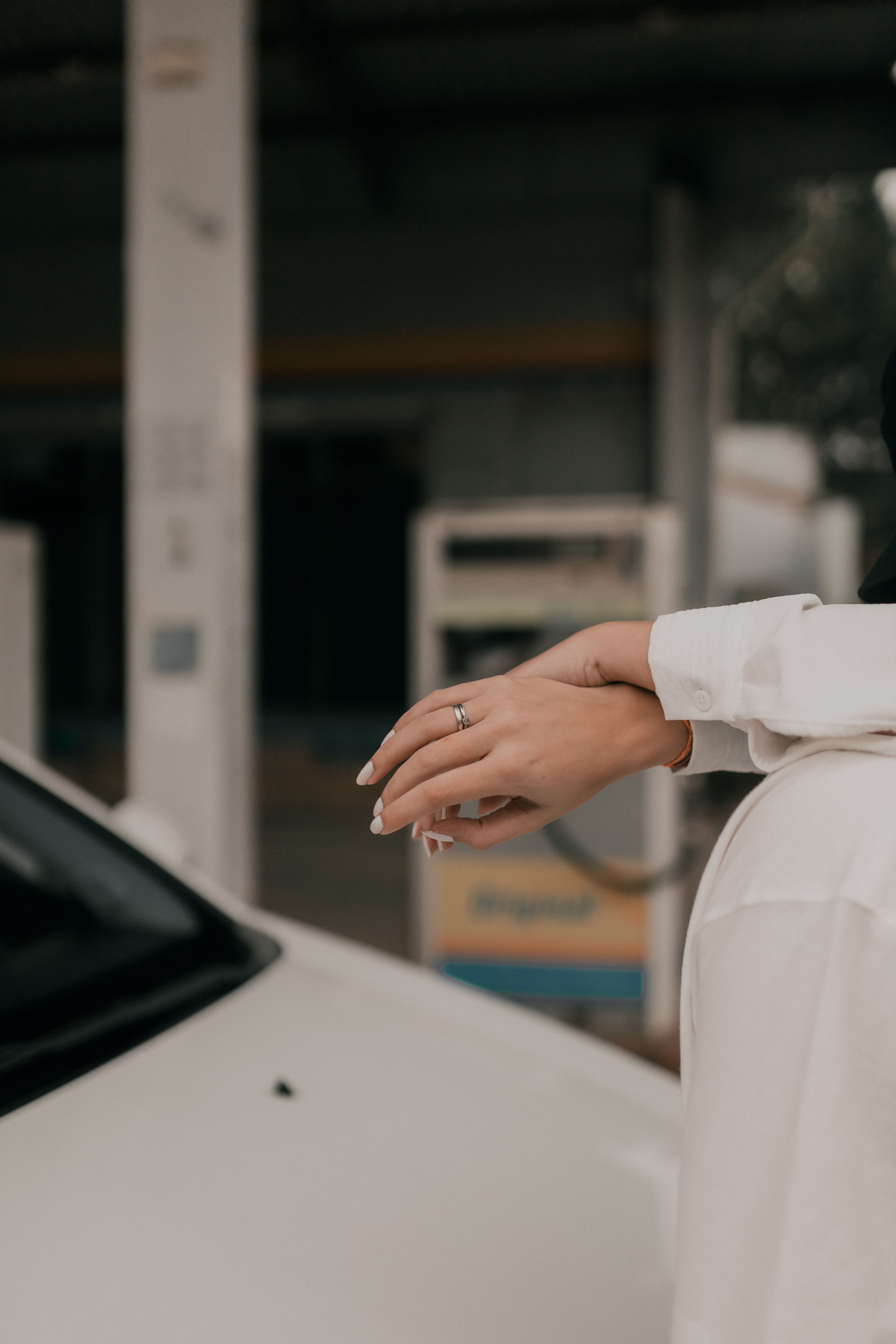 Elegant Hand with Engagement Ring at Gas Station