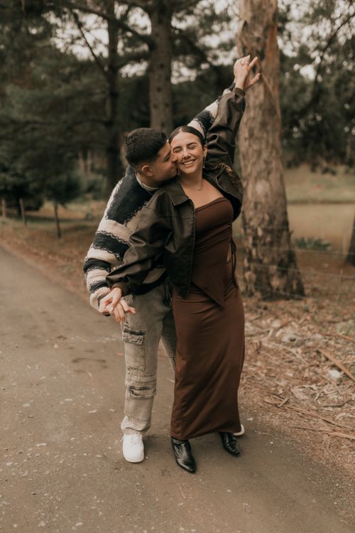 Free Loving couple walking happily down a forest path, enjoying a romantic moment together. Stock Photo