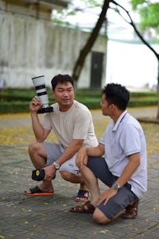 Two photographers having a casual discussion outdoors, holding professional camera equipment.