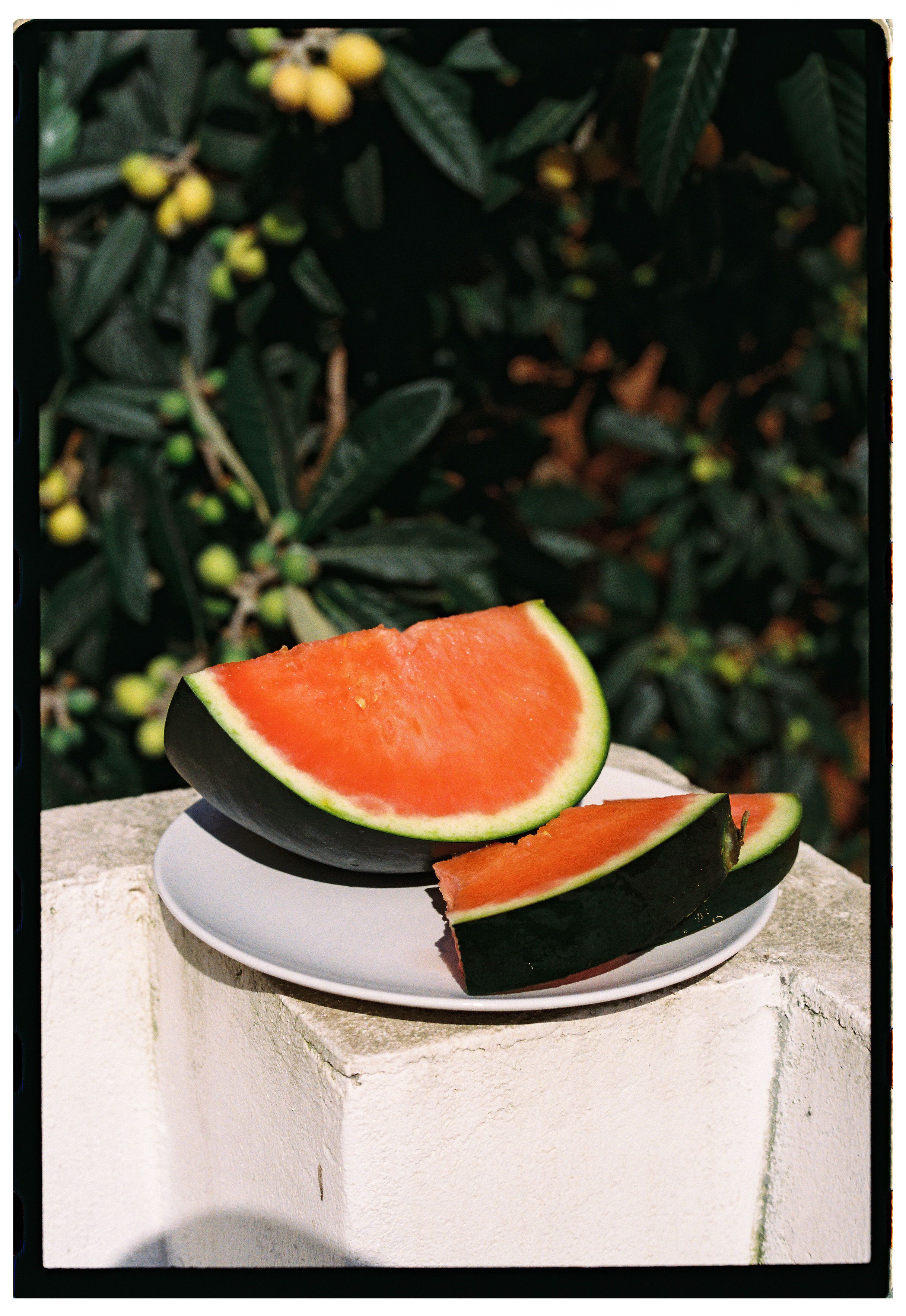 Juicy watermelon slices on a plate outdoors, perfect for a summer refreshment.