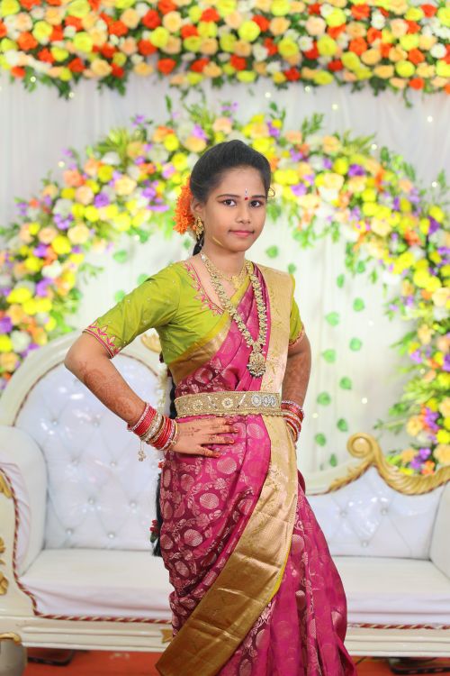 Free A woman in vibrant traditional attire stands confidently at a colorful celebration. Stock Photo