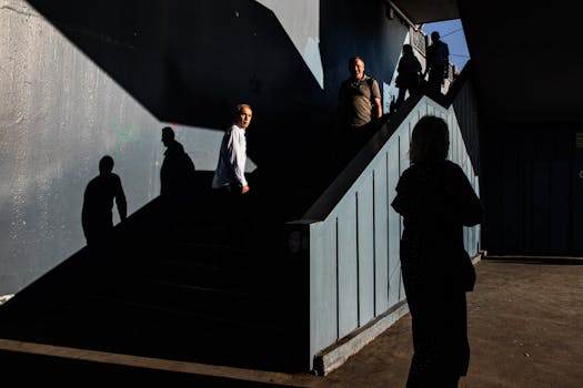 Dramatic shadow and light on stairway in Istanbul, capturing silhouette of people.