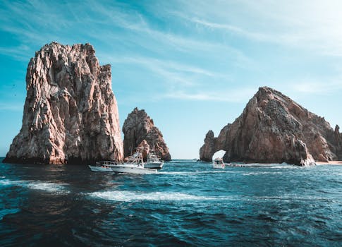 Stunning Cabo San Lucas seascape with rock formations and boats on a clear day.