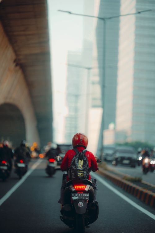 Free A motorcyclist rides through busy Jakarta streets, highlighting urban transportation. Stock Photo