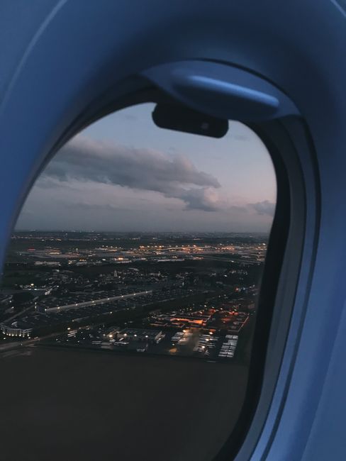 View from airplane window showing Villeneuve-sous-Dammartin landscape at twilight.