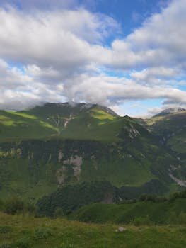 Breathtaking view of a lush green mountain range under a vibrant sky in Georgia.