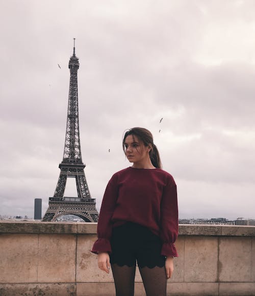 Woman in Red Long Sleeve Shirt Standing Near Eiffel Tower