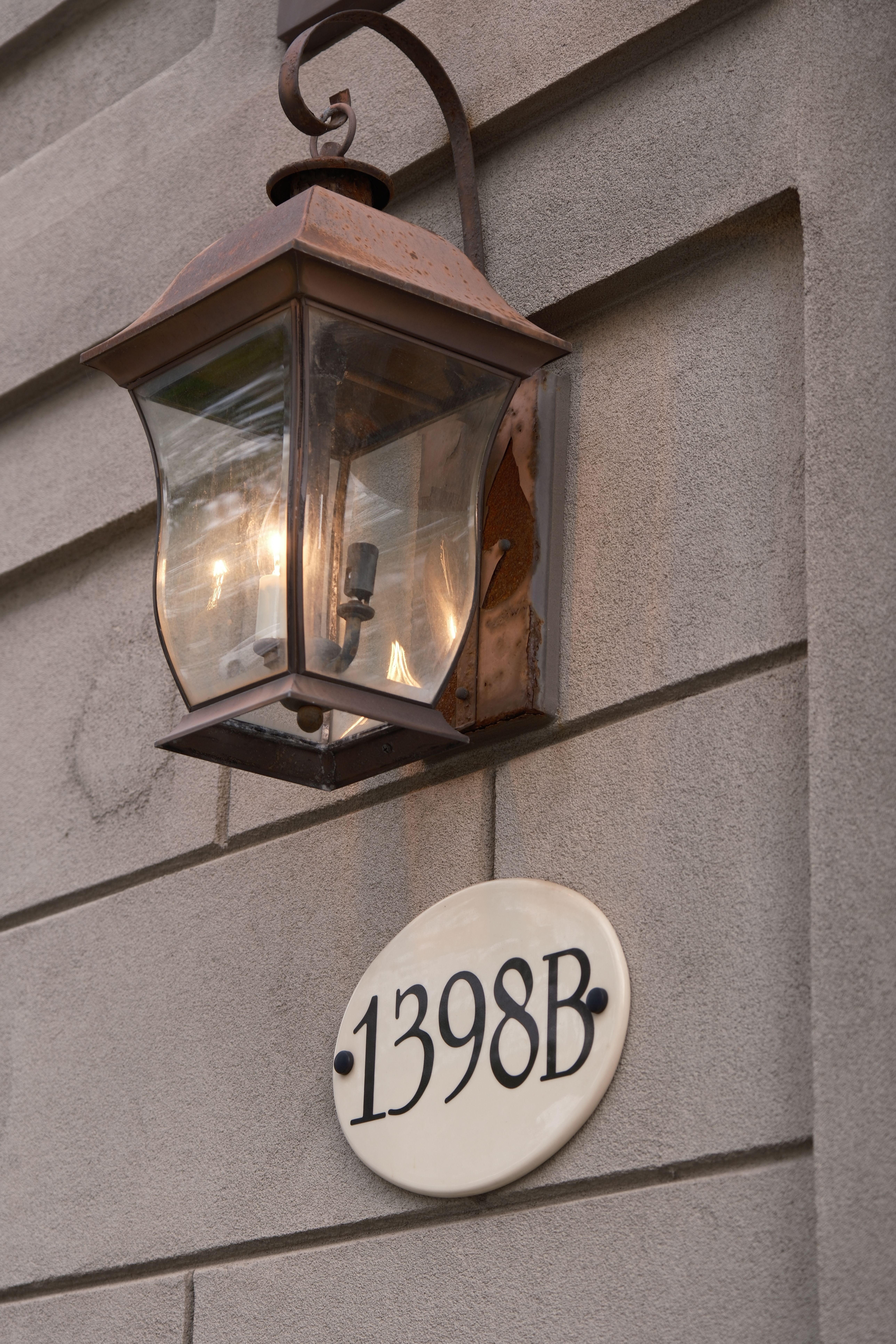 Vintage outdoor lantern and address plaque on a brick wall in Toronto, Canada.