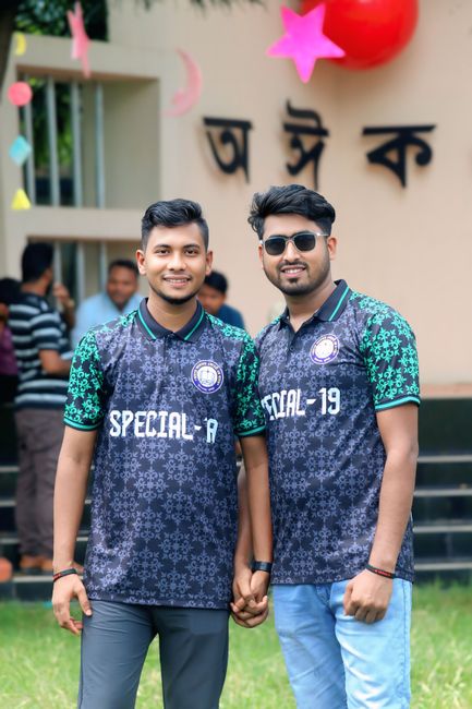 Two young men wearing matching jerseys enjoying outdoor celebration. Perfect for themes of friendship, celebration, and fashion.