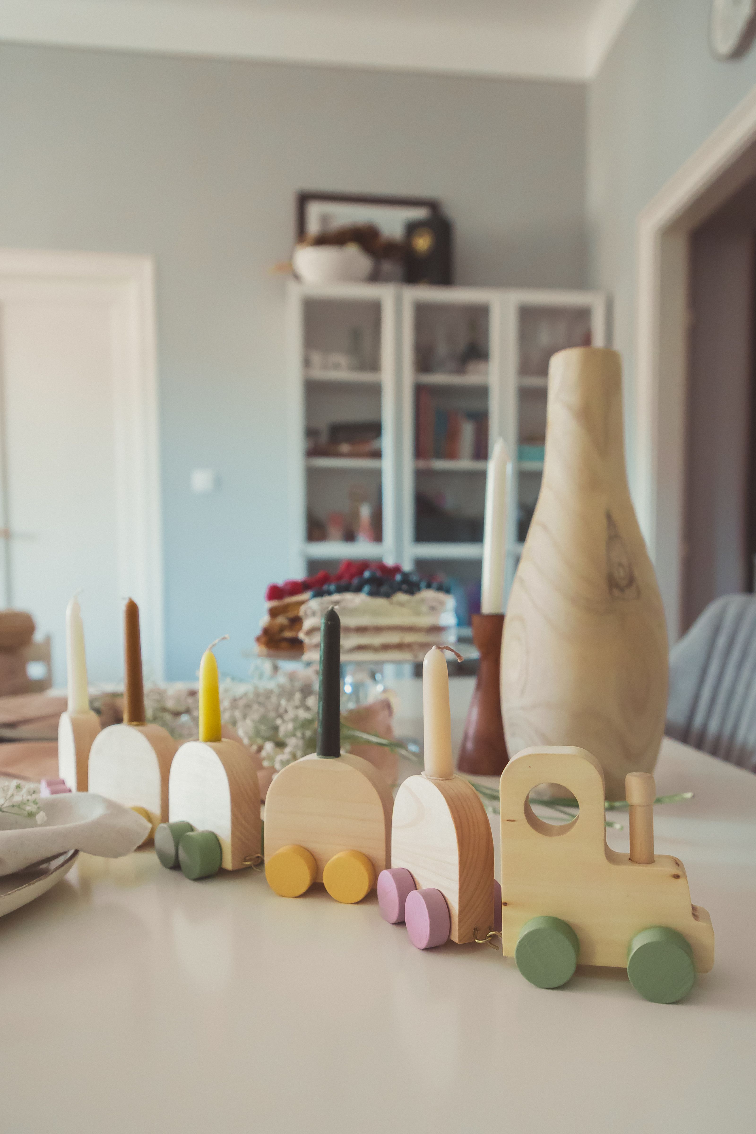 A cozy indoor setting featuring a wooden toy train and decorative elements on a table.
