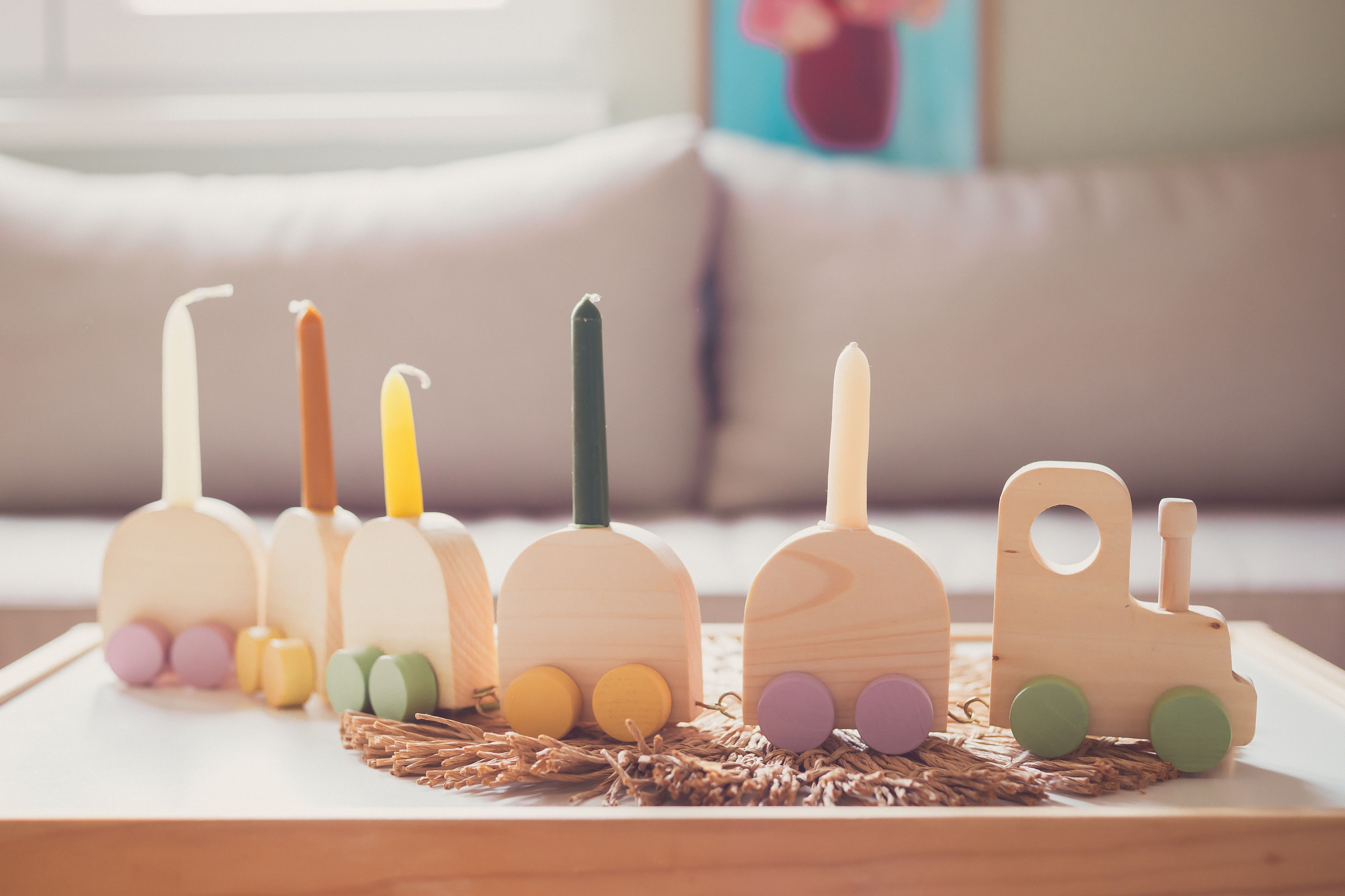 Brightly lit wooden train set with candles adds playful charm to interior decor.