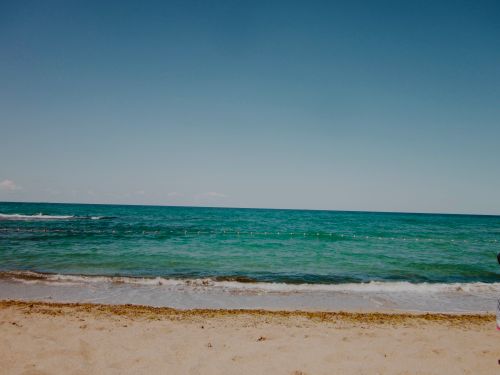 Free Serene beach with clear blue water and sandy shore, perfect for relaxation. Stock Photo