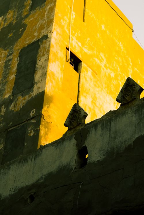 Free A striking yellow building facade with contrasting shadows and sky. Stock Photo