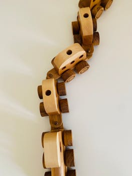 Artistic arrangement of wooden toy train cars on a white background, minimalistic style.