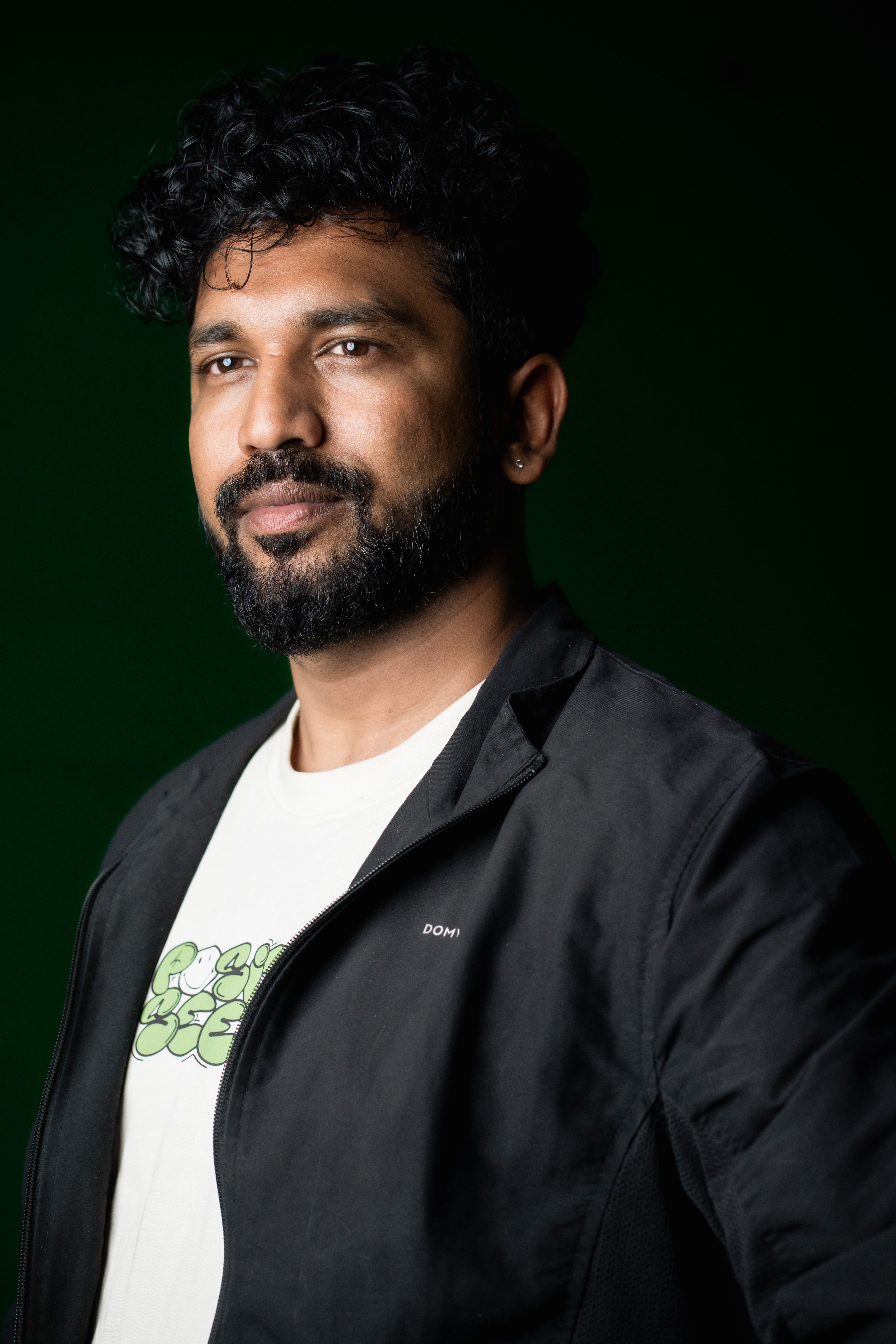 Closeup studio portrait of a thoughtful man with a green background.