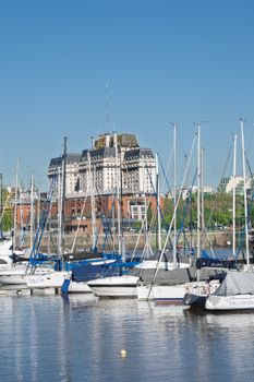 Yachts docked at the harbor in Buenos Aires with an elegant building in the background.
