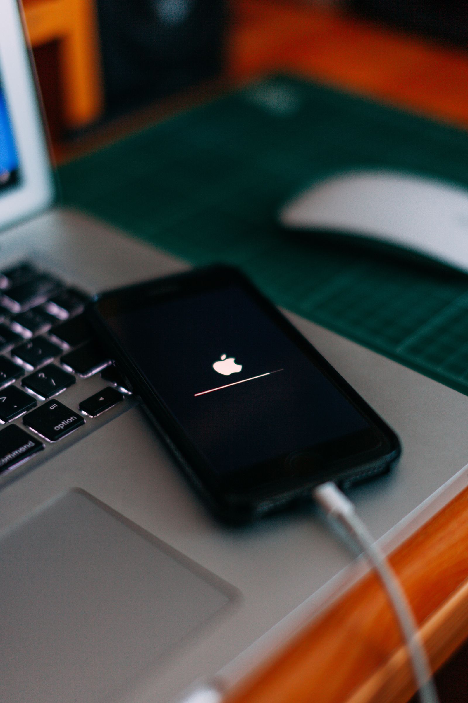 Şarj kablosuna bağlı iPhone ve dizüstü bilgisayar