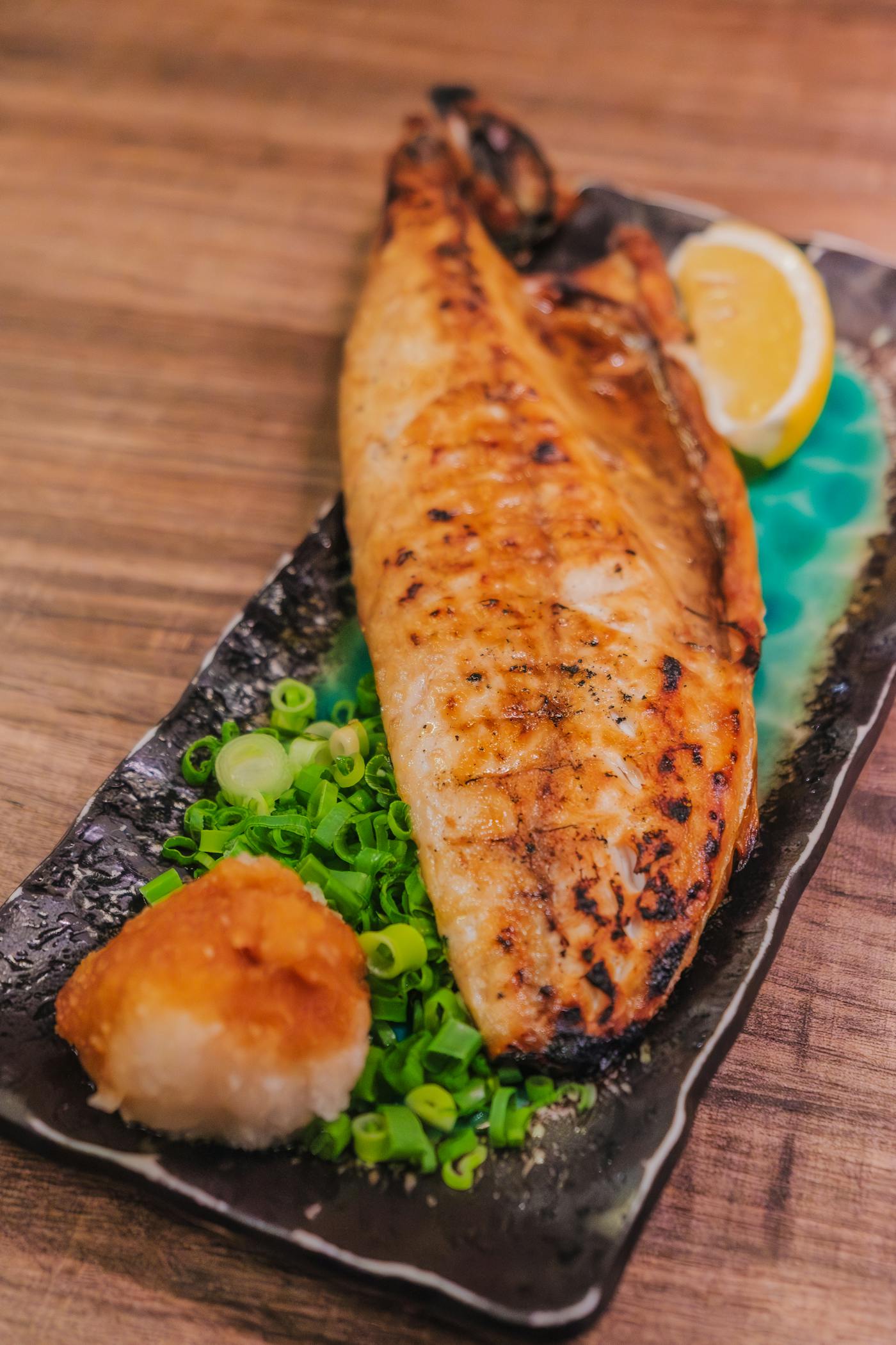 Filetto di sgombro alla griglia con fette di limone e erbe fresche