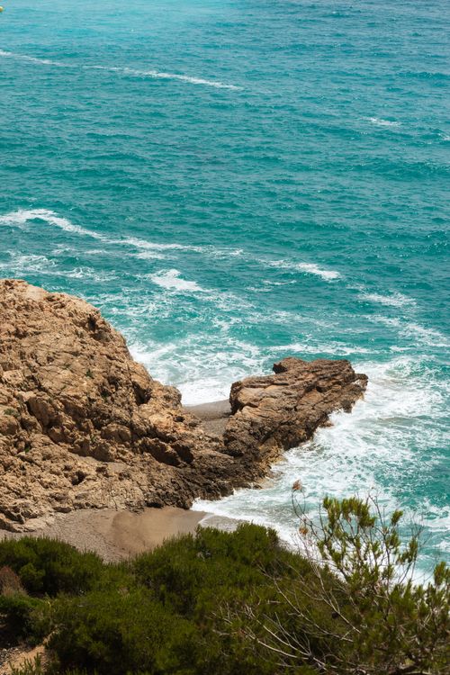 Free Captivating coastal landscape featuring rocky cliffs and turquoise ocean waves. Stock Photo