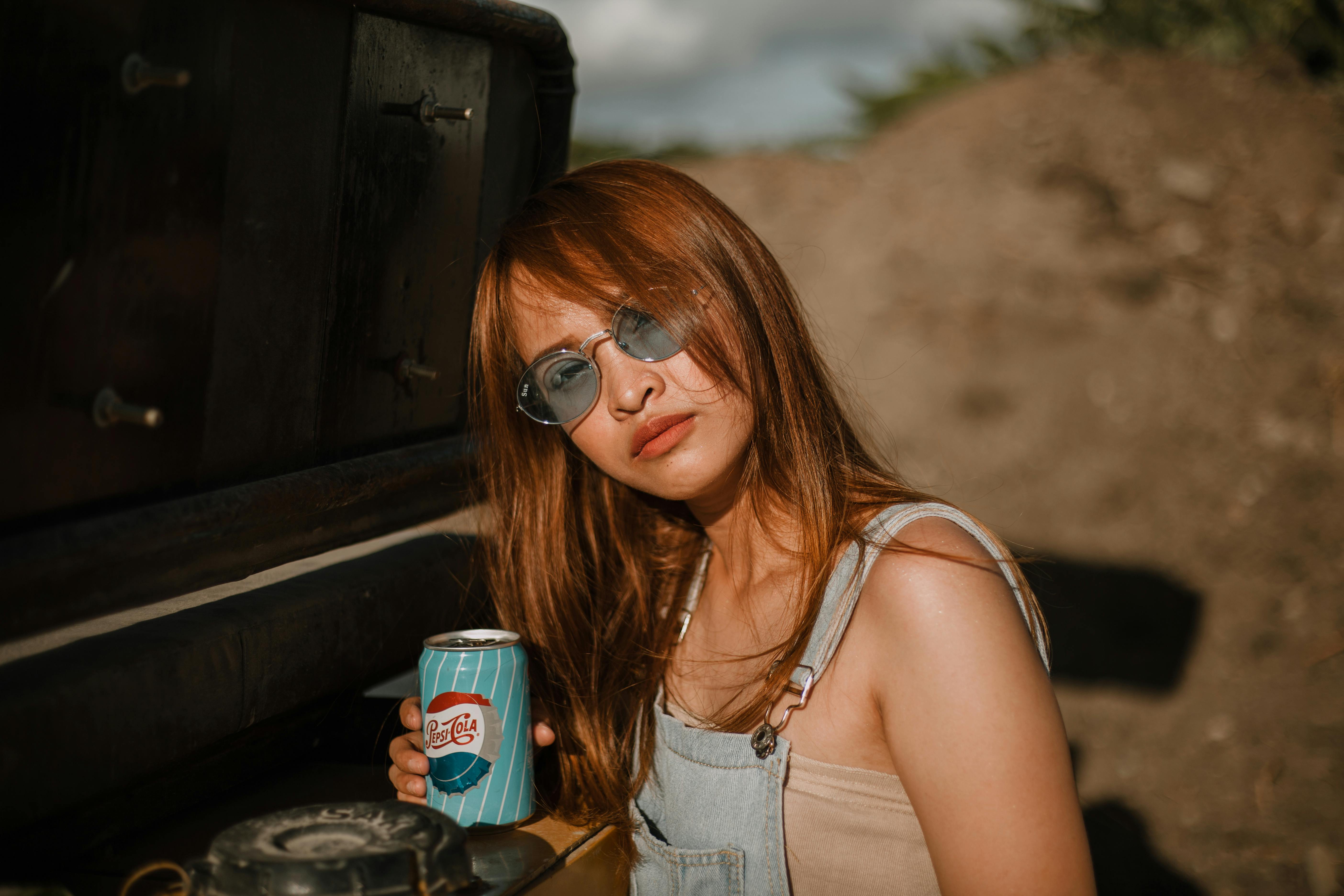 woman holding soda can