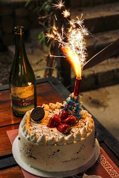 Delicious birthday cake with sparkler and strawberries, perfect for celebrations.