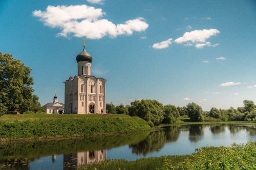 Free Scenic view of an Orthodox church reflecting in a serene river in Vladimir, Russia. Stock Photo
