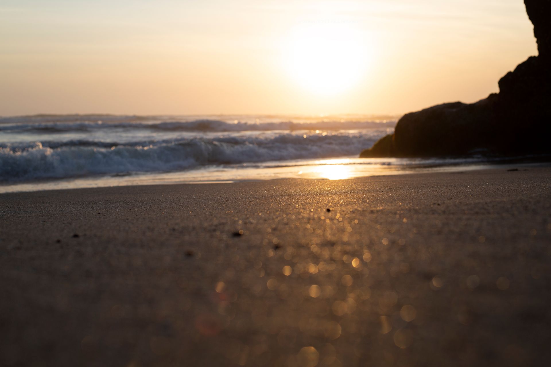 Experience the serene beauty of a Bali beach at sunset with golden sands and gentle waves.