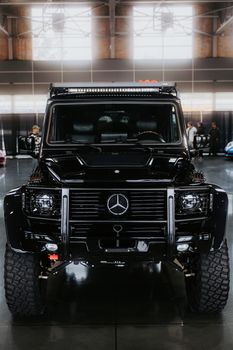 Front view of a sleek black SUV displayed in a modern indoor showroom. Perfect for luxury car enthusiasts.